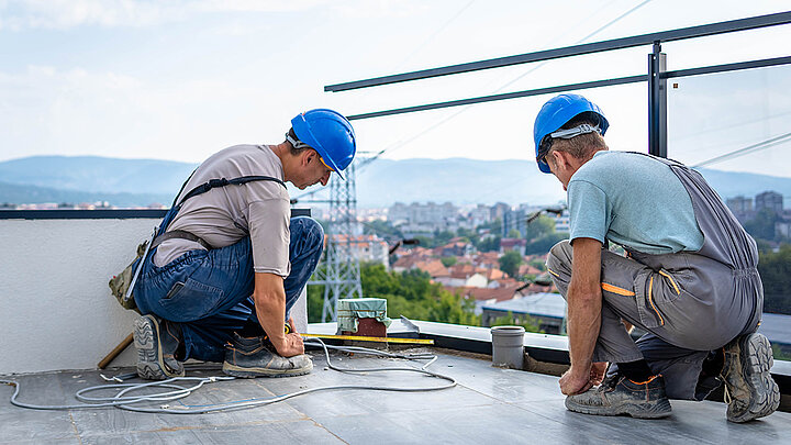 Zwei Handwerker arbeiten an der Ausführung einer Dachterrasse