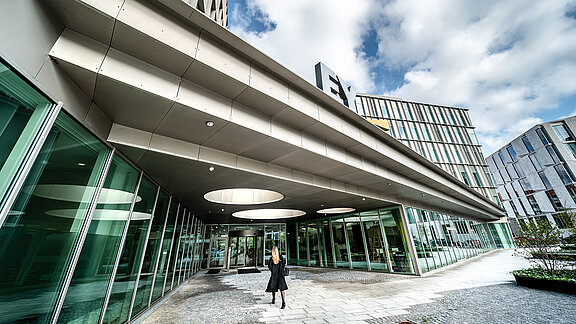 Modernes Bürogebäude von EY mit Glasfassade und überdachtem Eingangsbereich