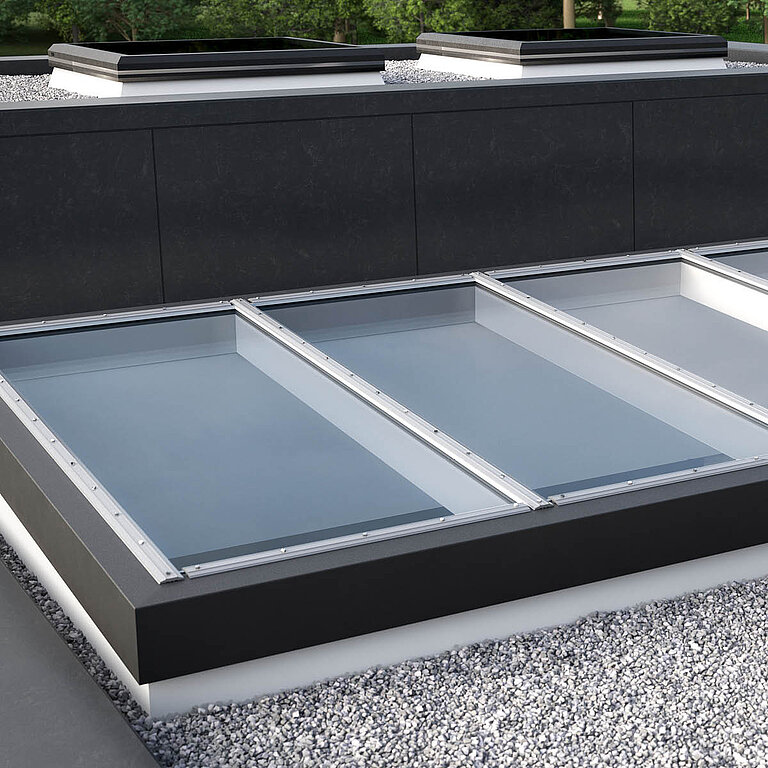 Nahaufnahme Glasdach Fire Resistance mit drei Feldern auf Flachdach mit Kiesumrandung.
