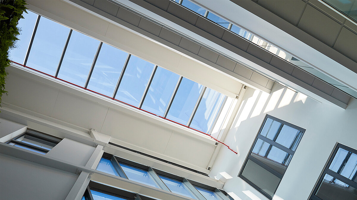 Innenansicht mit LAMILUX Glasdach PR60 und weißer Stahlkonstruktion im Atrium