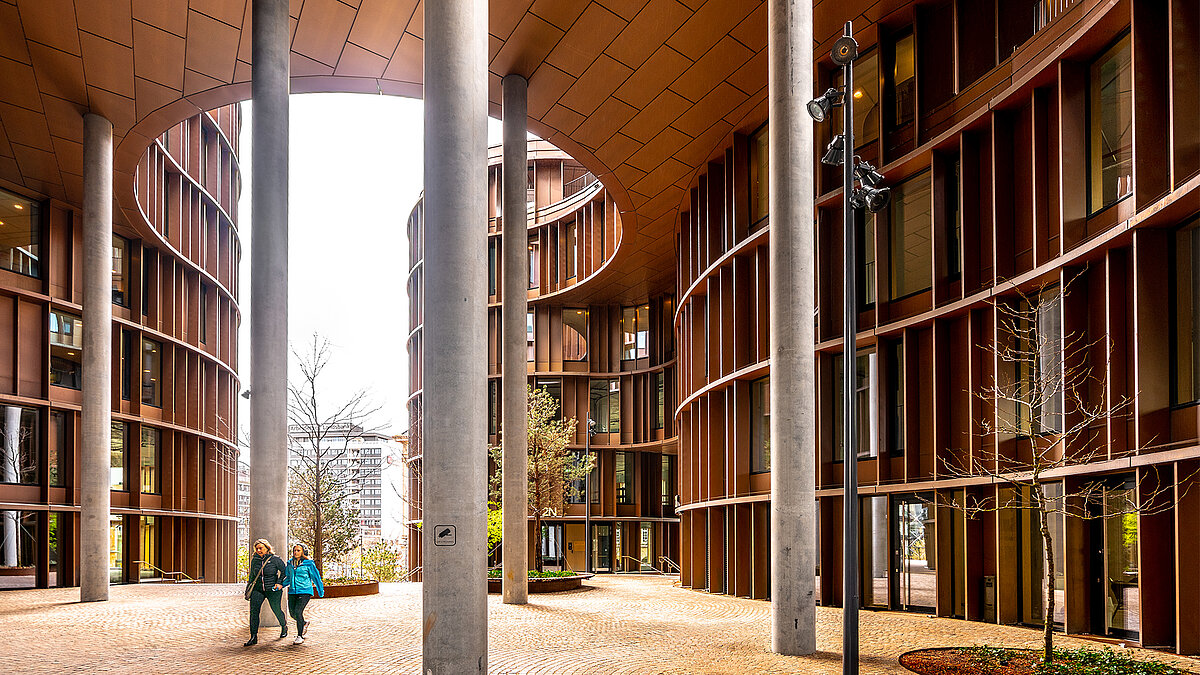 Moderner Innenhof mit geschwungener Fassade und hohen Säulen