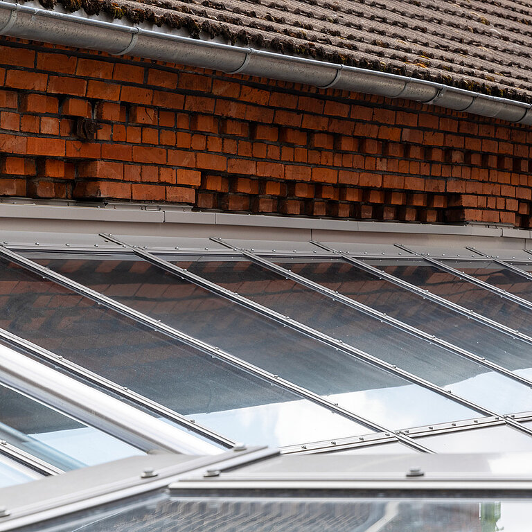 Glasdach Fire Resistance mit geneigter feuerbeständiger Verglasung und Ziegelhintergrund.