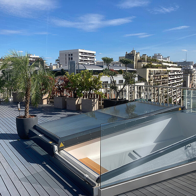 Geöffneter LAMILUX Flachdach Ausstieg Komfort Solo auf Dachterrasse mit hochgestellter Verglasung und direktem Zugang zur Dachfläch