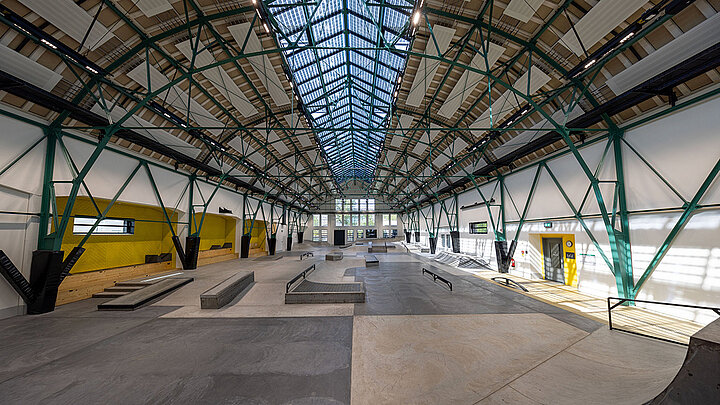 Skaterhalle mit weitläufiger Stahlkonstruktion und Glasdach für natürliche Tageslichtversorgung