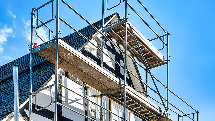 Haus mit Baugerüst für Dach- und Fassadenarbeiten