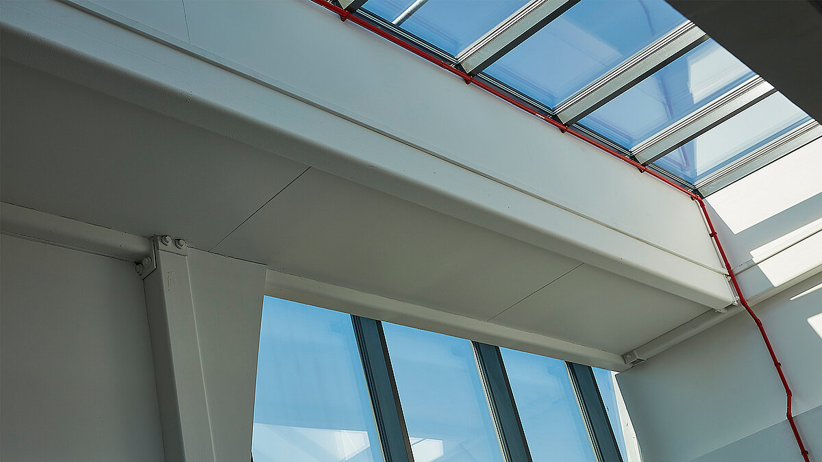 Innenansicht mit LAMILUX Glasdach PR60, weißen Trägern und großflächiger Verglasung