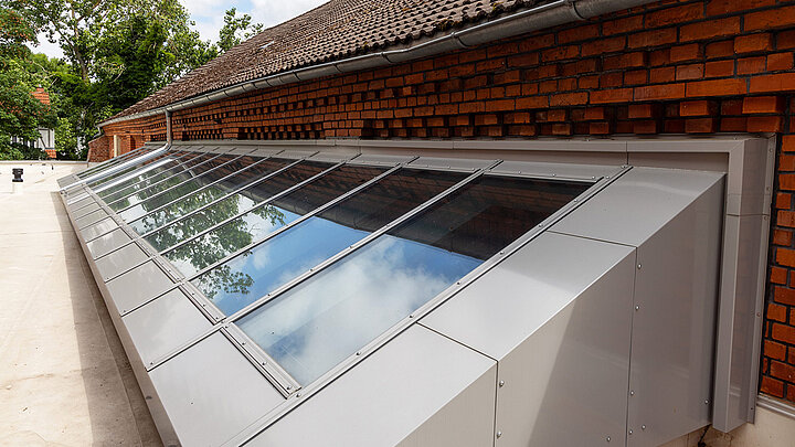 LAMILUX Glasdach Fire Resistance REI 30 als geneigte Glaslösung an Backsteinfassade