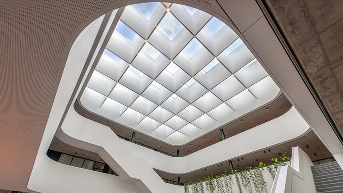 LAMILUX Flachdach Fenster FE 3° im Atrium mit Blick nach oben auf großflächiges Oberlich