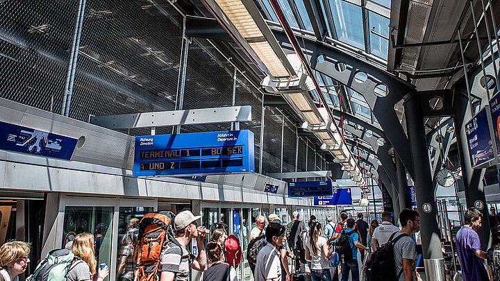 Menschen am Flughafenbahnhof Frankfurt beim Umsteigen Schalldämmung durch das Glasdach am Flughafenbahnhof Frankfurt