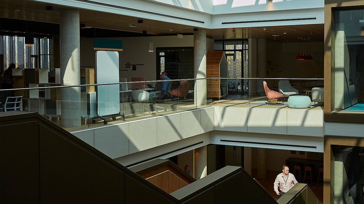 Modernes Bürogebäude mit mehreren Ebenen, Glasgeländern und offenem Atrium