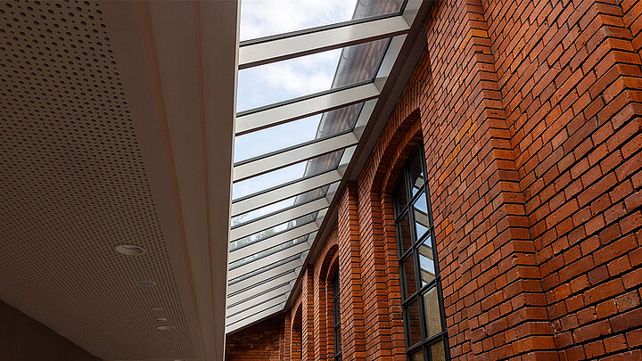 LAMILUX Glasdach Fire Resistance mit brandschutzgeprüfter Verglasung entlang historischer Backsteinfassade