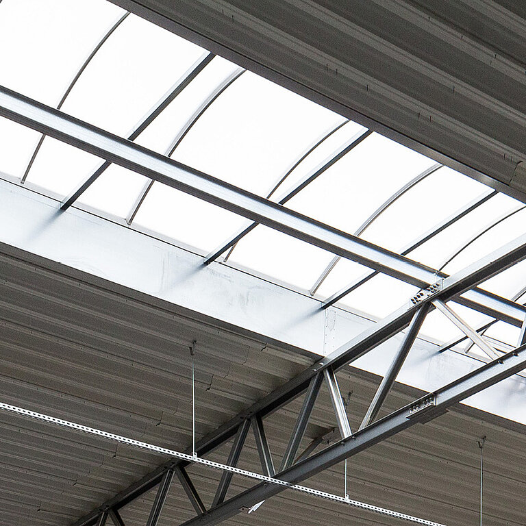 Innenansicht eines LAMILUX Lichtband B Passivhaus mit bogenförmiger Verglasung und Stahlkonstruktion
