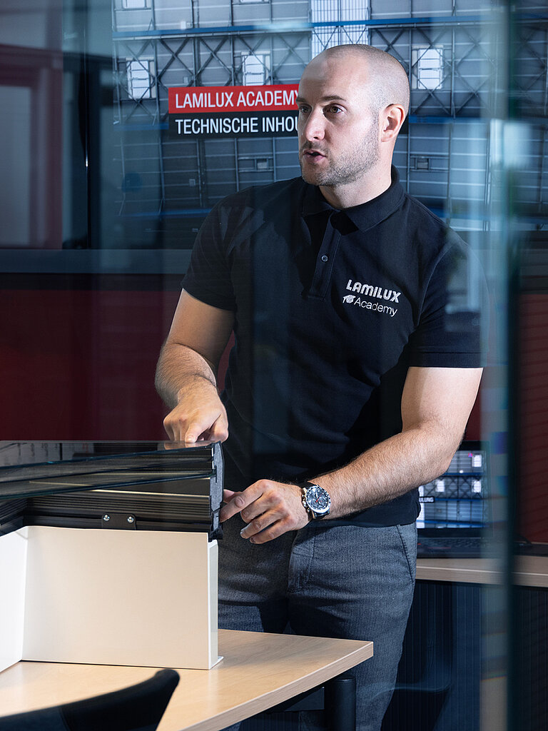 Mitarbeiter von LAMILUX erklärt am Modell