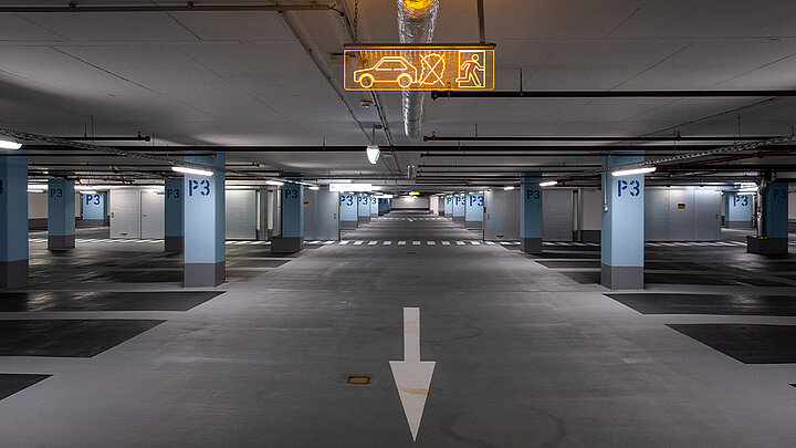 Tiefgarage mit markierter Fahrspur und Beleuchtung an der Decke