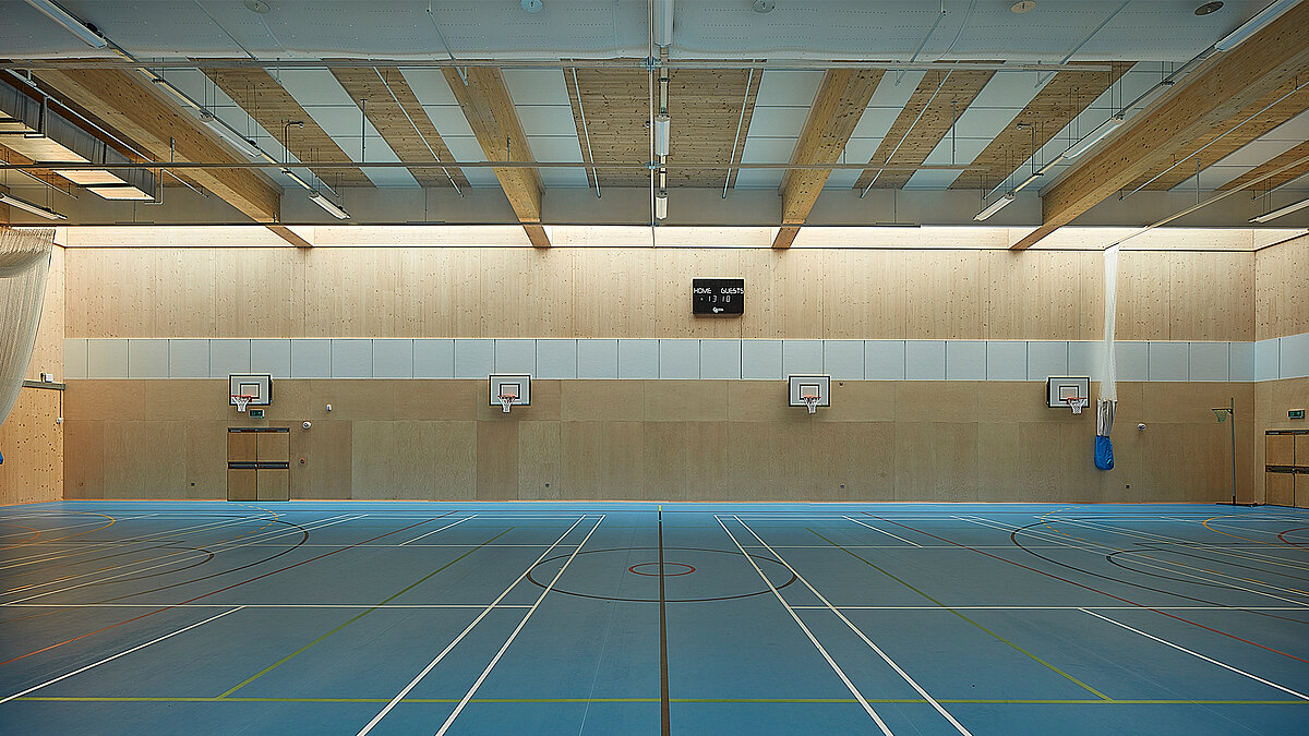 Sporthalle der Harris Academy Sutton mit Holzdecken, Mehrzweck-Spielfeld und Basketballkörben