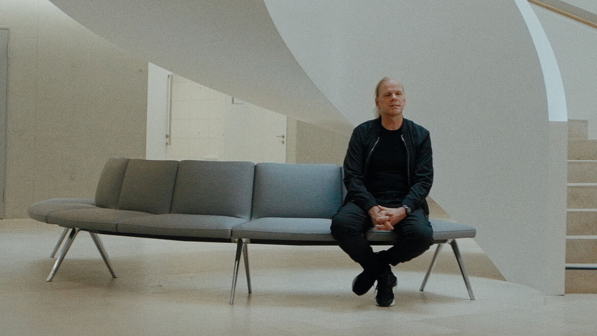 Torsten Gundlack (Architekt) sitzt auf einer Bank in vor einer Treppe