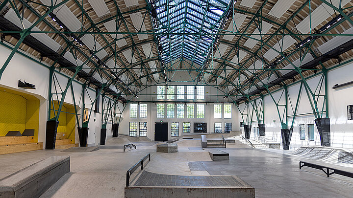 Moderne Skatehalle mit Rampen, Rails und Stahlträger-Dachkonstruktion