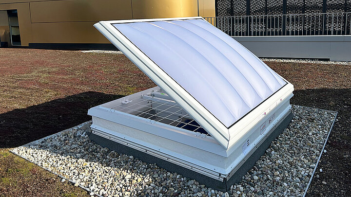 LAMILUX Lichtkuppel F100 W mit geöffnetem Flügel auf Flachdach