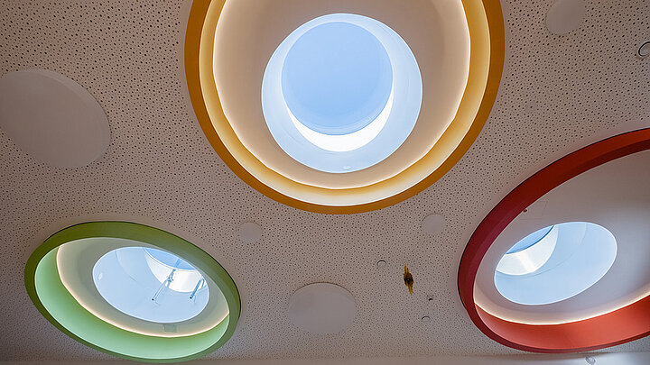 Innenarchitektur mit bunten runden Flachdach Fenstern in einer Kita | insights by LAMILUX