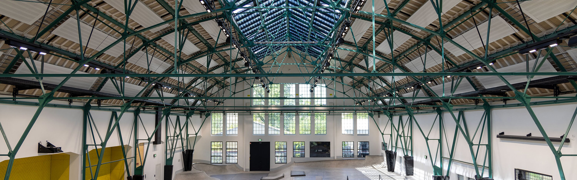 Große Industriehalle mit Stahlkonstruktion und Skatepark im Inneren
