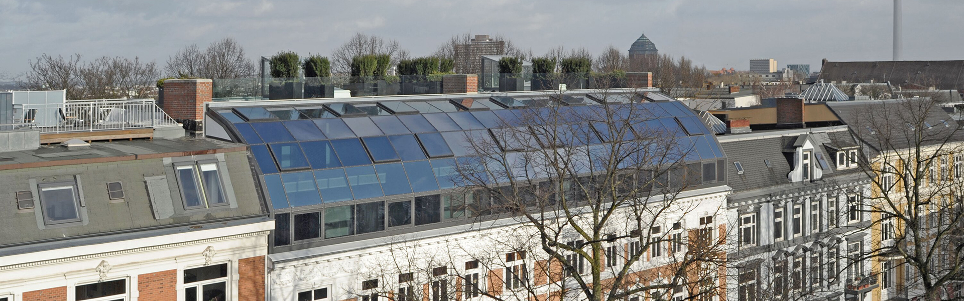 Großflächige Dachfenster auf geneigtem Dach eines Wohngebäudes in der Stadt
