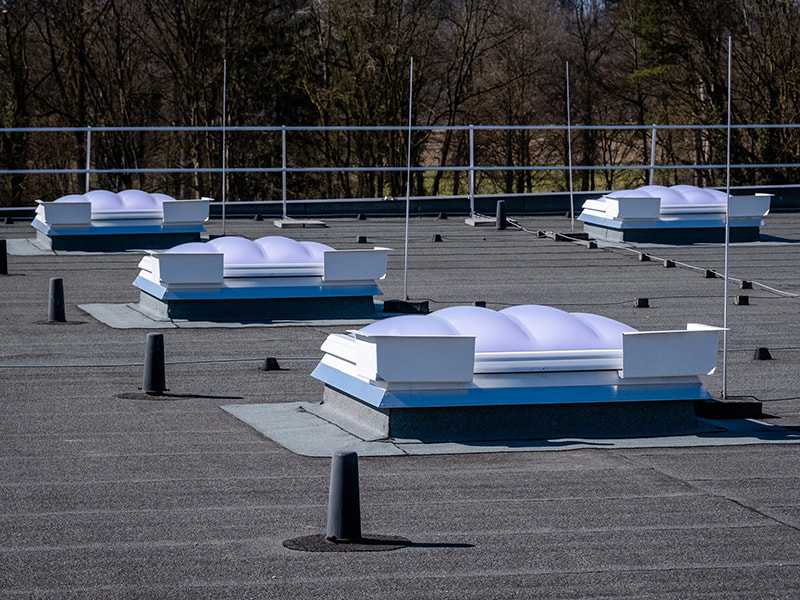 Lichtkuppeln auf einem mit Bitumen abgedichteten Flachdach 