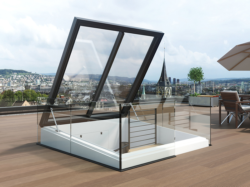 Moderne Dachterrasse mit aufklappbarem Glasdach und Blick auf eine Stadt mit Kirchturm.