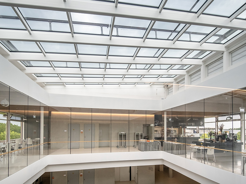 Atrium mit großem Glasdach für maximalen Tageslichteinfall.