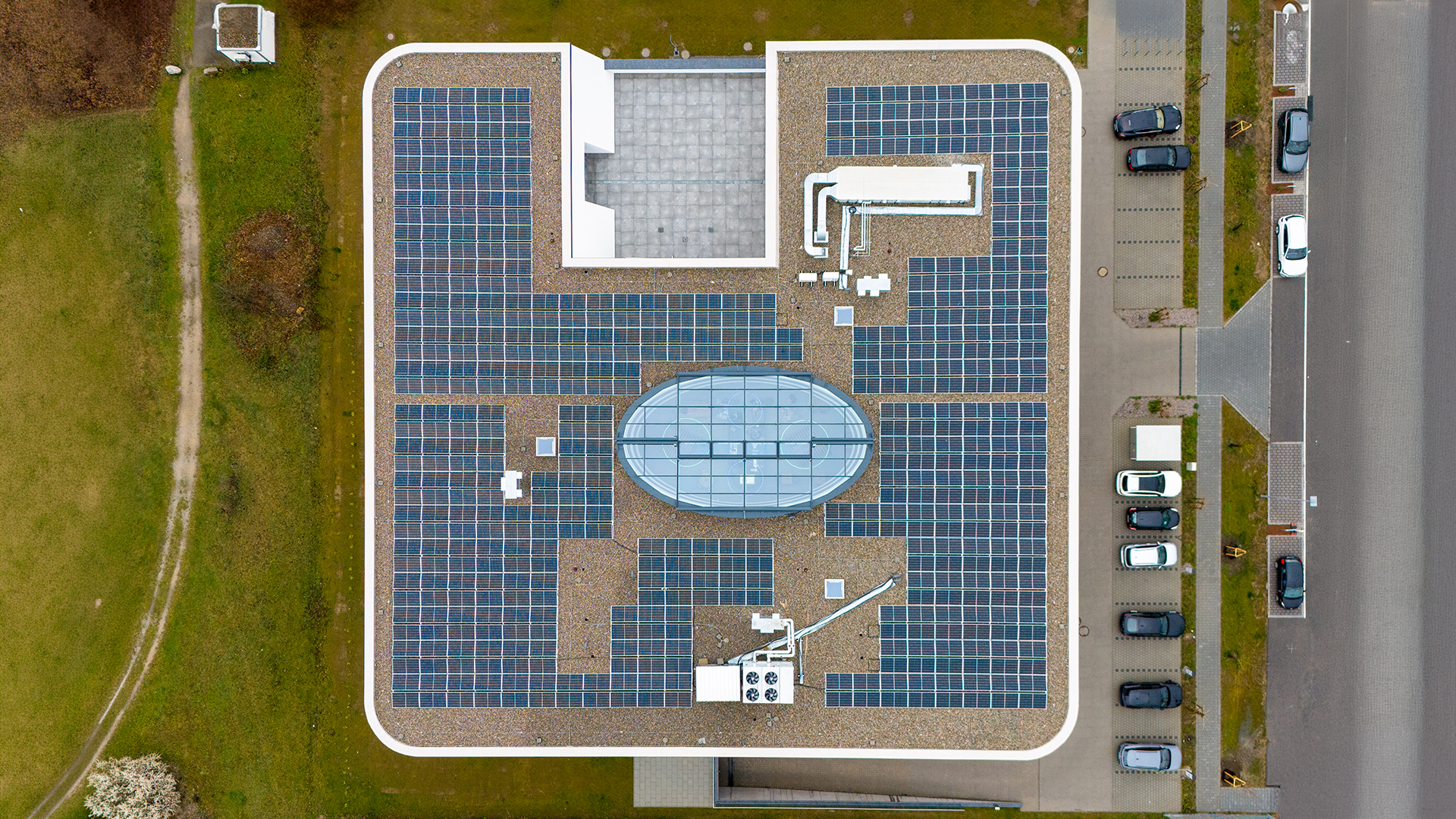 Luftaufnahme eines Industriegebäudes mit Photovoltaikanlage und zentralem Dachaufbau