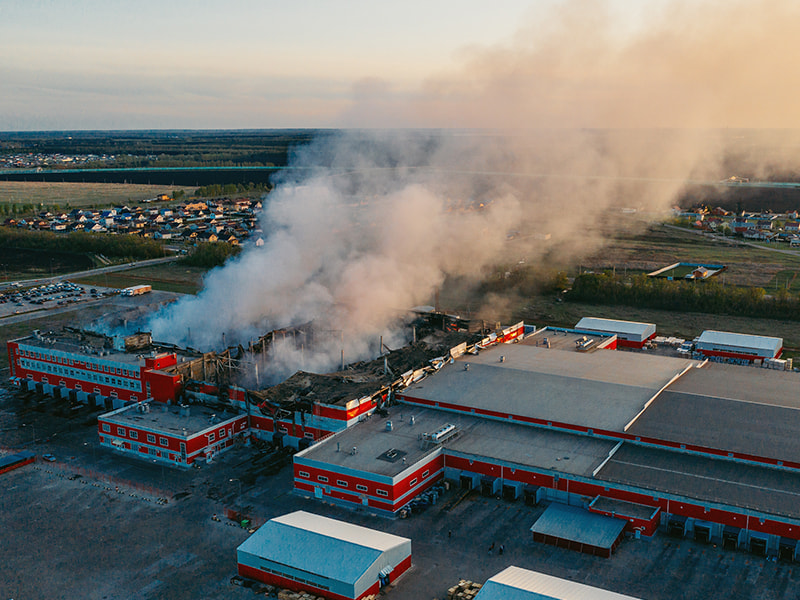 Brandrauch qualmt aus großer Industriehalle