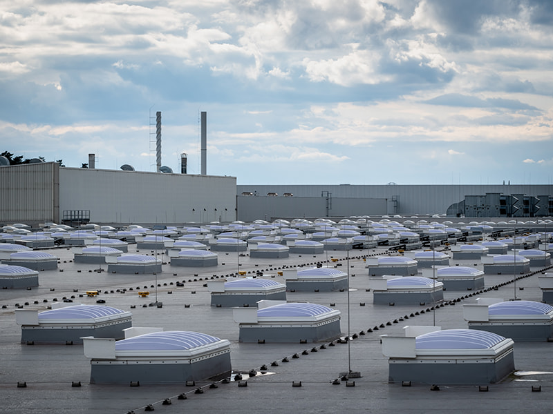 Großes Industriedach mit zahlreichen Lichtkuppeln und Lüftungsanlagen