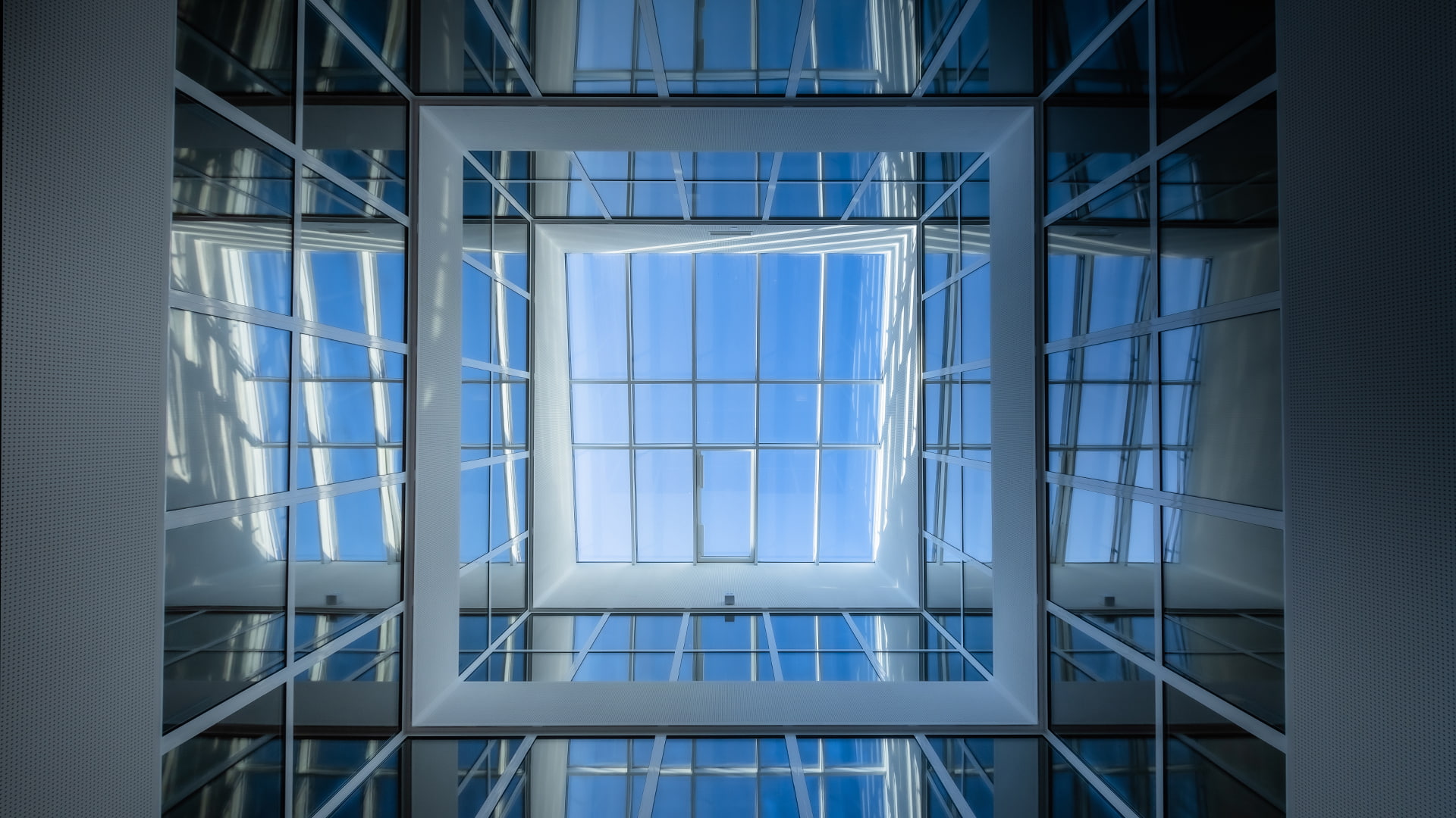 Blick nach oben im Atrium der Bertha-von-Suttner-Realschule in Köln mit großen Glasflächen und Tageslichteinfall.